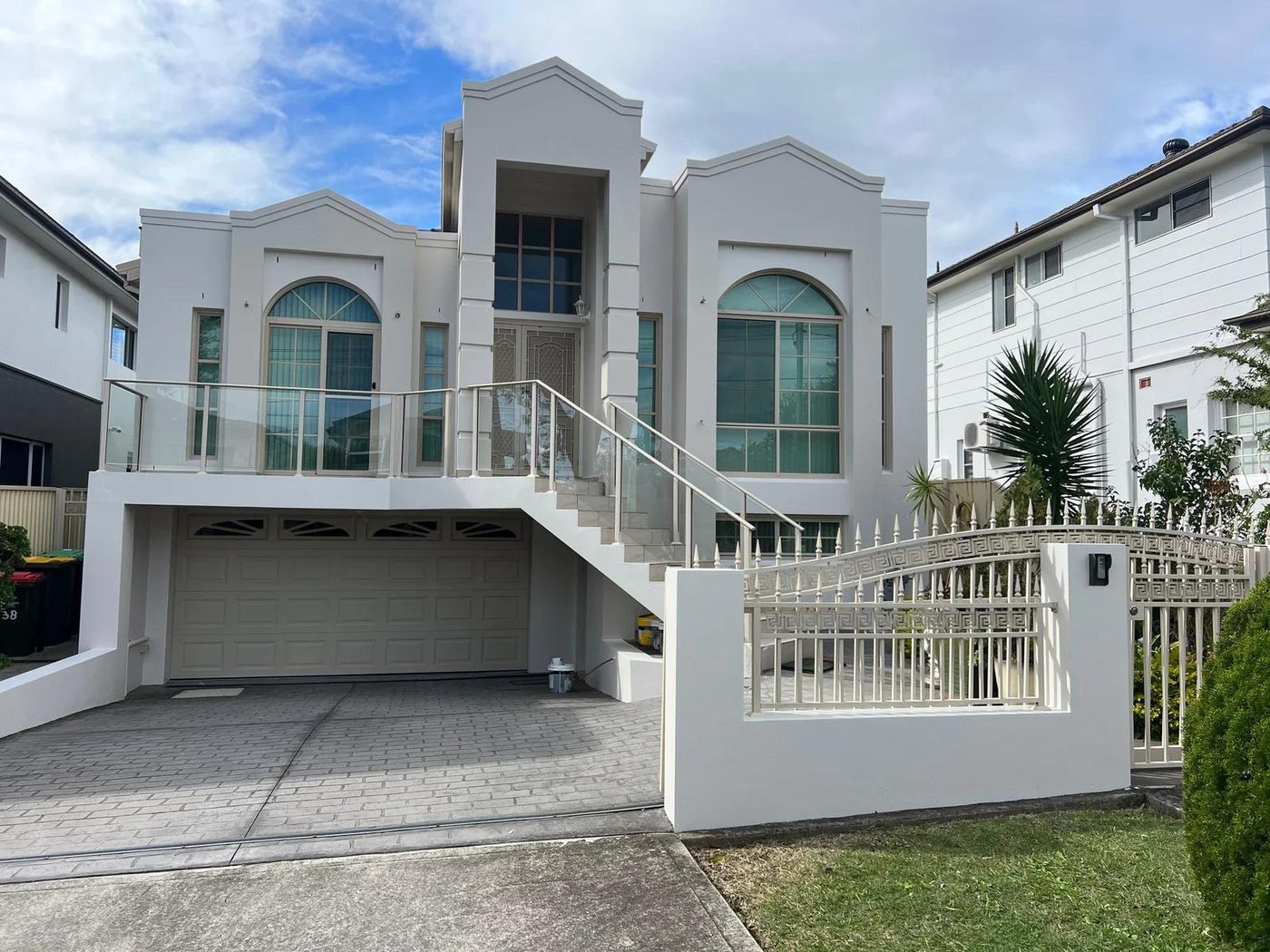 Freshly painted two-storey rendered home with arched windows